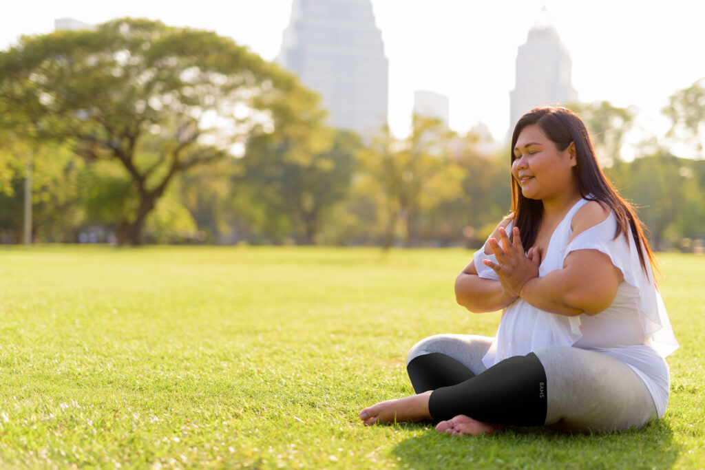 Beautiful Overweight Asian Woman Meditating And Doing Yoga In Lumpini Park